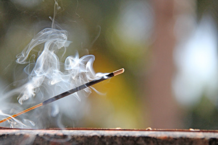 Incense stick and smoke from incense burning. Beautiful smoke. Blurred background and design with copy space.の写真素材