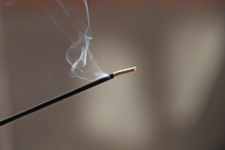 Incense stick and smoke from incense burning. Beautiful smoke. Blurred background and design with copy space.の写真素材