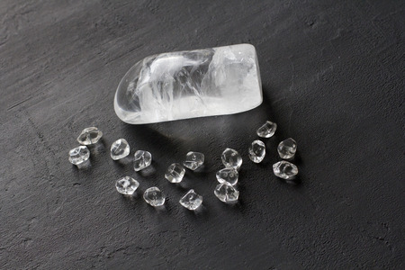 Stone rhinestone, rock crystal. Natural transparent stones lie on a black modern background. Spa,...