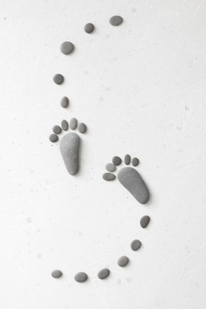 Footprints made of stones. Happy feet. Stone arranged like footprints on the beach. Spa background...