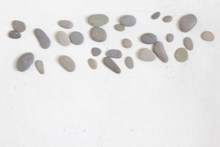 Spa background with grey stones, gray modern background, cover, template with round gray stones, flat lay. Copy space for your text. Stones scattered on a gray background.の写真素材