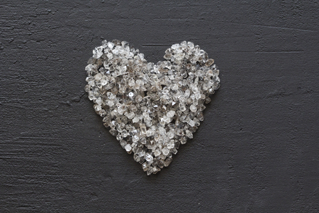 Heart of stones, love. Scattered diamonds on black background. Raw diamonds and mining, a scattering of natural diamond stones. Graphite quartz. Natural stones and minerals. Copy space for your text.の写真素材