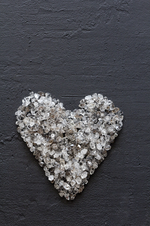 Heart of stones, love. Scattered diamonds on black background. Raw diamonds and mining, a scattering of natural diamond stones. Graphite quartz. Natural stones and minerals. Copy space for your text.の写真素材