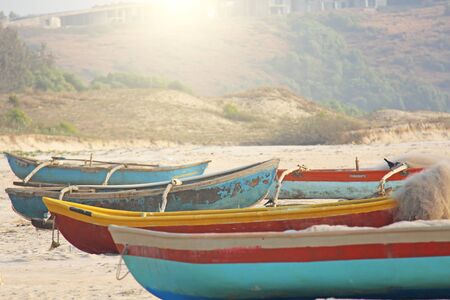 Bright colorful boats for fishing were on the shore of the Indian Ocean. India, Goa.の写真素材