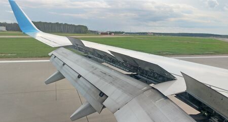 Airplane wing view out of the window on the cloudy sky The Earth background. Holiday vacation...