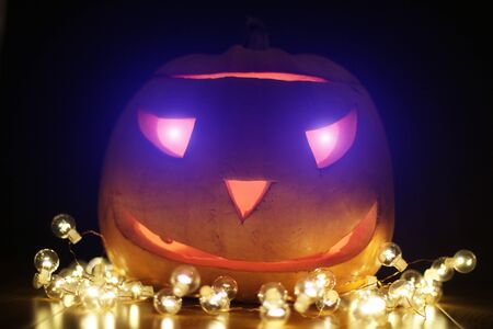 Halloween Pumpkins head. Orange pumpkin with a smile and glowing eyes. Neon.の写真素材