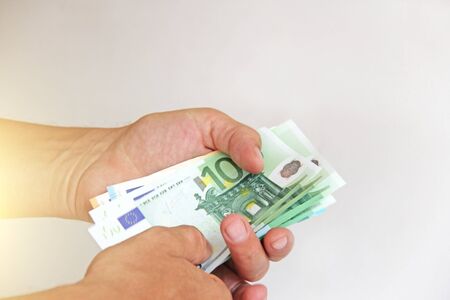 The man's hand holds the euro, considers them and pays. Paper money euros in the hands.