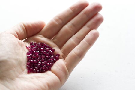 A natural ruby lies in the hand. Natural stones, ruby located in the female hand. The hand holds a ruby. Copy space for your text.の写真素材