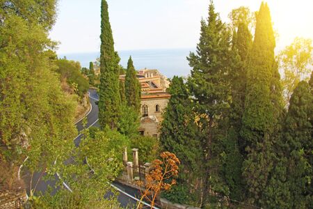 The road Serpentine. Mountain Winding Road in the City of Taormina. Red Bus. The island of Sicily, Italy.の写真素材