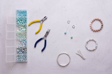 Making of handmade jewellery. Top view. Beads, tools for creating jewelry. Preparation for handmade. Create jewelry, bracelets from natural stones with your own hands. Flat lay. On white background.の写真素材