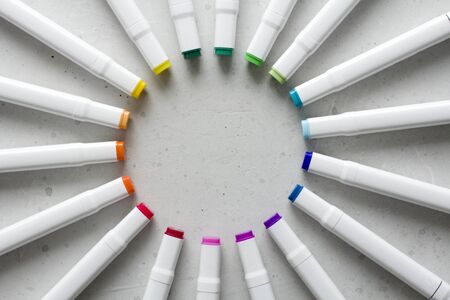 A set of bright multi-colored felt-tip pens or markers lie in a circle, rays, creating a round frame in the center. Creativity, drawing for children, design. Many Markers of all colors of the rainbow.の写真素材