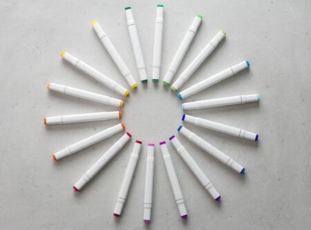 A set of bright multi-colored felt-tip pens or markers lie in a circle, rays, creating a round frame in the center. Creativity, drawing for children, design. Many Markers of all colors of the rainbow.の写真素材