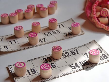 Russian lotto, bingo board game, barrels and cards on a white background. Quarantine Games Concept. Board game lotto with wooden barrels. Money game, luck, luck, excitement, board games, stay home.の写真素材