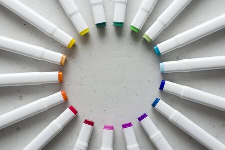 A set of bright multi-colored felt-tip pens or markers lie in a circle, rays, creating a round frame in the center. Creativity, drawing for children, design. Many Markers of all colors of the rainbow.の写真素材