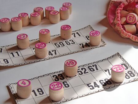 Russian lotto, bingo board game, barrels and cards on a white background. Quarantine Games Concept. Board game lotto with wooden barrels. Money game, luck, luck, excitement, board games, stay home.の写真素材