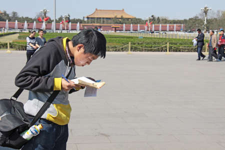 China, Beijing - April 8, 2012. A Chinese tourist in Beijing looks at the map.のeditorial素材