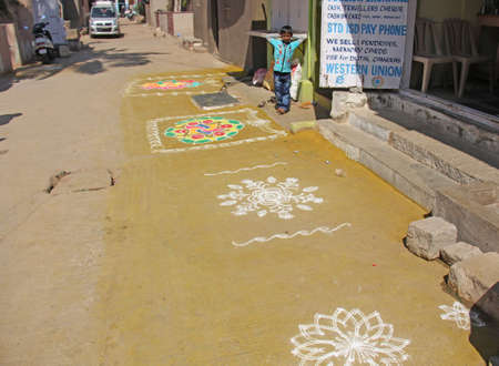 India, Hampi, 02 February 2018. The ancient mandalas are painted with chalk and paints on the ground in the village of Hampi. The boy is in the street. Hampi, Vijayanagar, karnataka, unesco.のeditorial素材