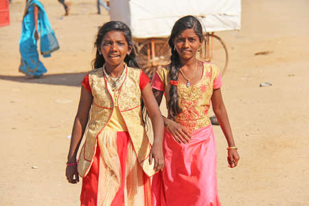India, Hampi, 02 February 2018. Young girls in beautiful saris walk down the street and smile.のeditorial素材
