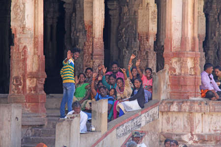 India, Hampi, 01 February 2018. A group of Indian people, bright men and women, waving hands inside the Virupaksha temple, smiling and giving greetings.のeditorial素材