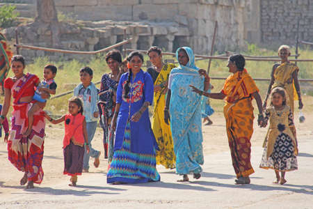 India, Hampi, 02 February 2018. The main street of Hampi village is women in bright and colorful saris, men, children, a group of people. Indian people. Motorcycle.のeditorial素材