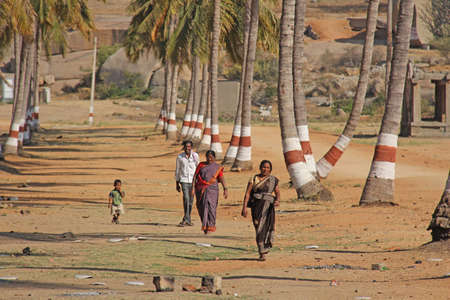 India, Hampi, 02 February 2018. Children, men and women in a sari walk in a palm grove. People of India.のeditorial素材