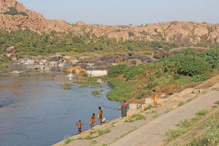 India, Hampi, 02 February 2018. Bath day on the river in the village of Hampi - Tungabhadra. The men are washing on the river in Hampi.のeditorial素材