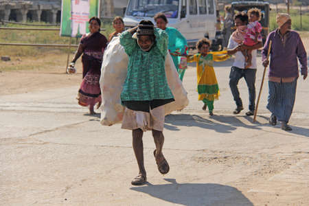 India, Hampi, 02 February 2018. A scavenger. Indian man with a big bag of plastic bottles. Ecology in India and Asia. Problems of ecology and garbage collection.のeditorial素材