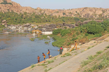 India, Hampi, 02 February 2018. Bath day on the river in the village of Hampi - Tungabhadra. The men are washing on the river in Hampi.のeditorial素材