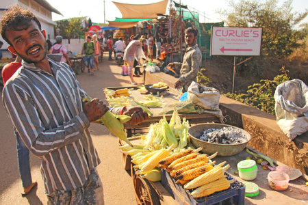 India, GOA, January 24, 2018. The seller of cooked and baked corn. Street trading in India, selling corn. Street delicious food.のeditorial素材