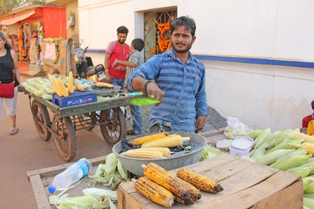 India, GOA, January 24, 2018. The seller of cooked and baked corn. Street trading in India, selling...