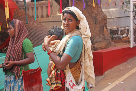 India, GOA, January 28, 2018. Poor woman with a baby in her arms. The woman is a beggar. Poverty in India.のeditorial素材