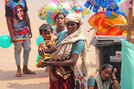 India, GOA, January 28, 2018. Poor woman with a child asks for money on the street in India. A...