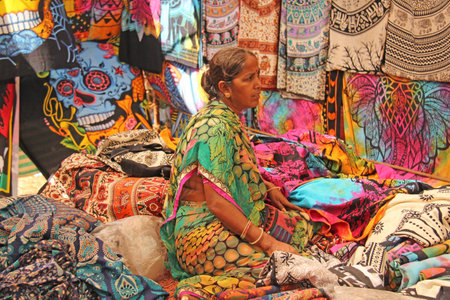 India, GOA, January 24, 2018. Indian sellers in the Anjuna market, Goa, India. Indian markets, trade. A store of scarves, carpets and stoles. Bright colors of India.のeditorial素材