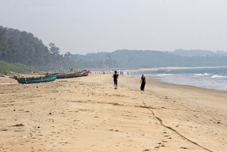 India, GOA, January 22, 2018. People walk along the seashore. Boats on the beach or on the beach.のeditorial素材