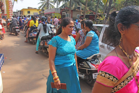India, GOA, January 28, 2018. The streets of India. People go or ride a scooter down the street. Bright colors of India. Holiday in India.のeditorial素材