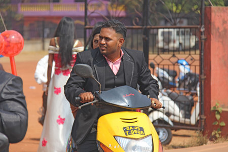 India, GOA, January 28, 2018. The streets of India. People go or ride a scooter down the street. Bright colors of India. Holiday in India.のeditorial素材