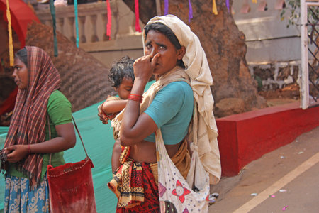 India, GOA, January 28, 2018. Poor woman with a baby in her arms. The woman is a beggar. Poverty in India.のeditorial素材