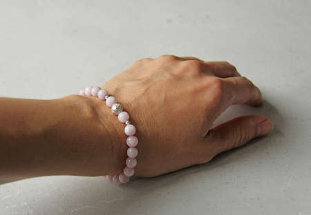 kunzite bracelet. A bracelet made of stones on a hand from a natural stone kunzite. Bracelet made of natural stones. Handmade jewelry. Handmade bracelets on light modern background.の写真素材