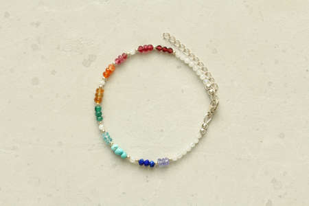 Bright multicolored bracelet. Bracelet made of stones on hand from natural stone Bright multicolored. Bracelet made of natural stones. Handmade jewelry. Handmade bracelets on light modern background.の写真素材