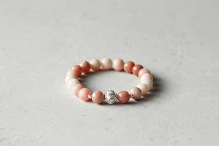 Pink opal bracelet. A bracelet made of stones on a hand from natural stone Pink opal. Bracelet made of natural stones. Handmade jewelry. Handmade bracelets on light modern background.の写真素材