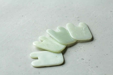 Gouacha Massage of face and body. Massager gouacha made from natural stone mineral White jade. Therapeutic healing massage for beauty and youth of face, body. Copy space for your text.の写真素材