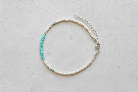 Turquoise and pearls bracelet. Bracelet made of stones on hand from natural stone Turquoise pearls. Bracelet made of natural stones. Handmade jewelry. Handmade bracelets on light modern background.の写真素材