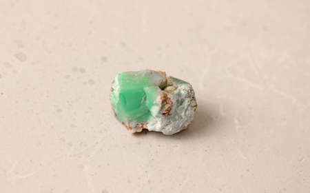 Natural chrysoprase stone lies is on a light background. Natural stones, crystals for magic, lithotherapy, geology, minerals, stone collection. Chrysoprase green natural stone nugget.の写真素材