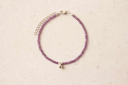 Amethyst bracelet. A bracelet made of stones on a hand from natural stone Amethyst. Bracelet made of natural stones. Handmade jewelry. Handmade bracelets on light modern background.の写真素材
