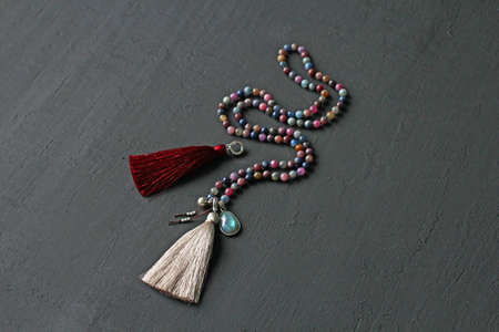 Rosary mala 108 beads from natural stones tourmaline lie on black modern background. Author's jewelry from natural stones, Buddhism, mantra, prayer, rosary from stones for prayer, beauty. Long beads.の写真素材