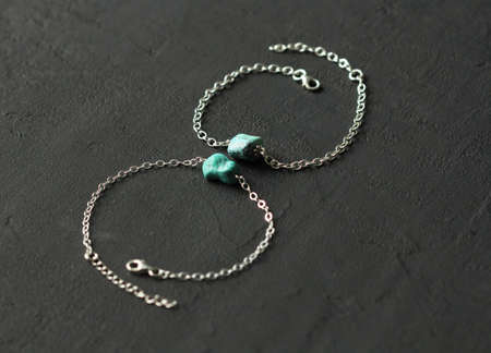 Turquoise nugget two bracelets on a silver chain, on a black modern background. Bracelet made of...