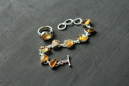 Citrine bracelet, ring. Bracelet made of stones on hand from natural stone Citrine. Bracelet made of natural stones. Handmade jewelry. Bracelets on light modern background. Stylish stone jewelry.の写真素材
