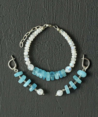 Handmade jewelry Bracelet, earrings in aquamarine and moonstone, set against a modern black background. Beautiful designer bracelet, earrings made of natural stones and silver. Aquamarine, moonstone.の写真素材