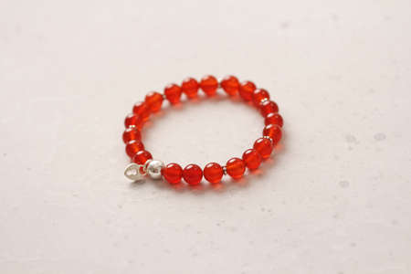Carnelian bracelet. Bracelet made of stones on hand from natural stone Carnelian. Bracelet made of natural stones. Handmade jewelry. Handmade bracelets on light modern background. Heart.の写真素材