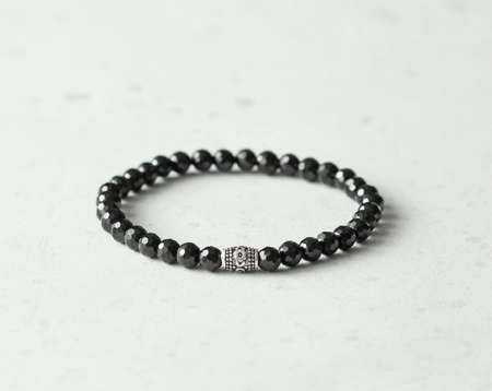 Chrome diopside bracelet. A bracelet made of stones on a hand from natural stone Chrome diopside. Bracelet made of natural stones. Handmade jewelry. Handmade bracelets on light modern background.の写真素材